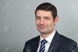 18915078-A-head-and-shoulders-shot-of-a-40-year-old-business-man-in-a-suit-and-shirt-with-blue-tie-Stock-Photo-300x200